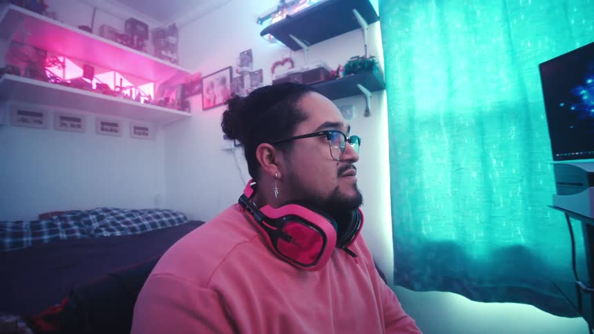 Man sitting in front of a gaming setup and interacting in a concentrated manner