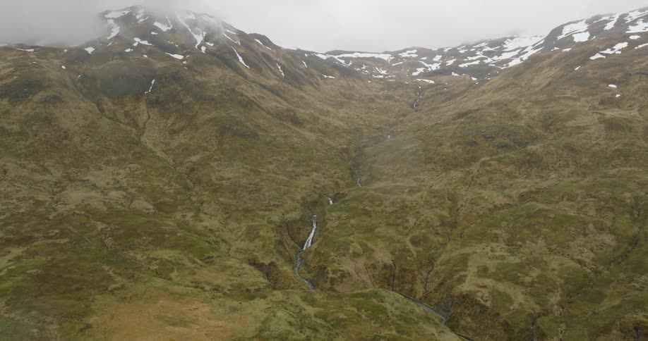 Aerial panorama of a river in a mountain with a snowy peak