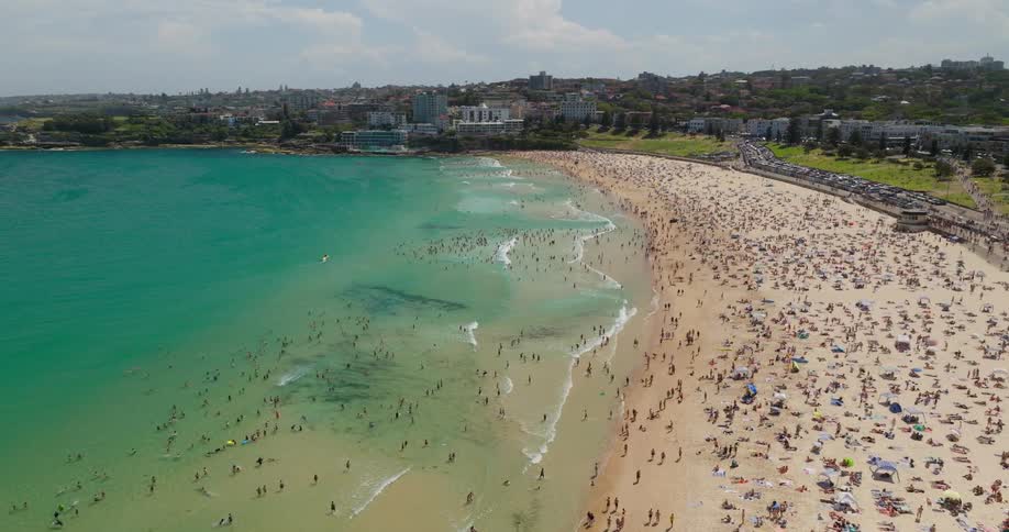 Aerial view of a very crowded beach with people swimming and sunbathing