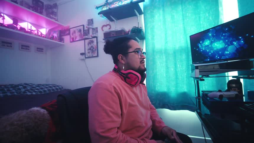 Man playing video games in a room and cheering