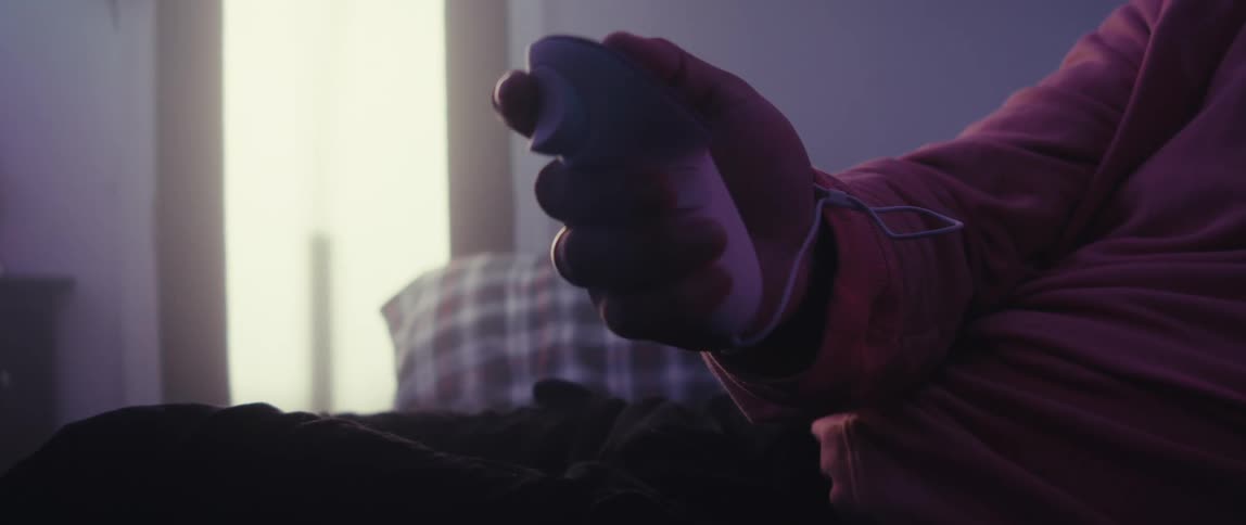 Man sitting in a room using vr headset holding a controller in his hand