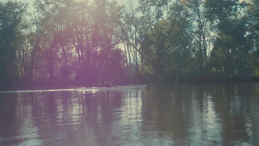 Person canoeing on a river during the day