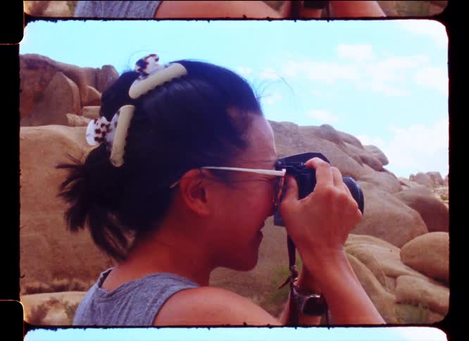 Woman in a natural rock environment taking pictures with a professional camera