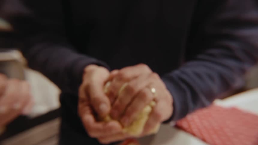 A person kneading dough by folding dough by hand on the kitchen