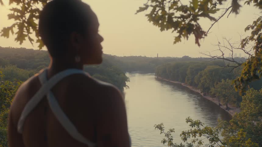 A woman stands over the river taking in the view