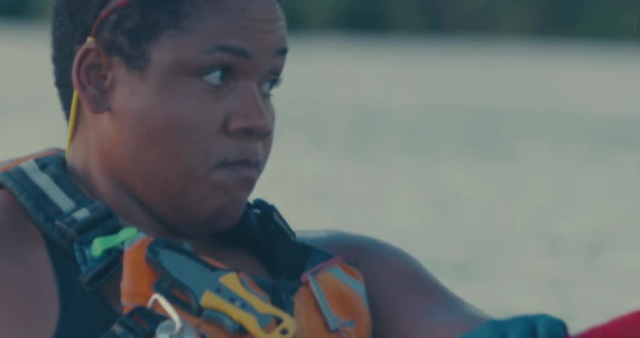 A woman concentrates deeply as she paddles through water
