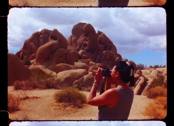 Woman using a professional camera in a rocky environment