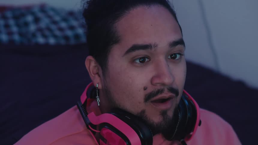 Portrait of a man with headphones around his neck making a surprised facial expression