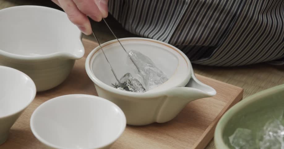 Hand putting ice cubes in a bowl