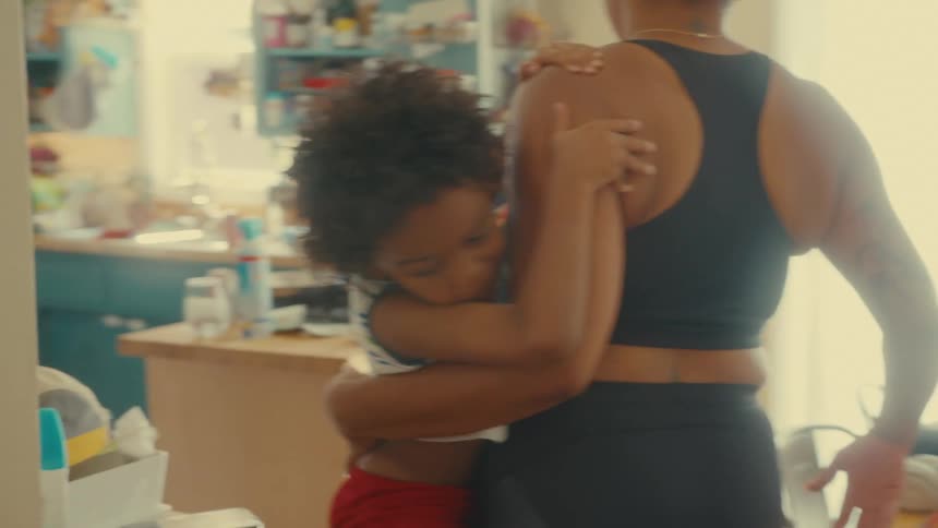 A father has trouble carrying his young son to the kitchen