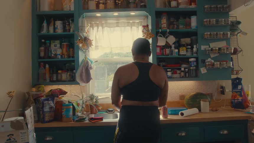 A woman is washing the dishes in the kitchen