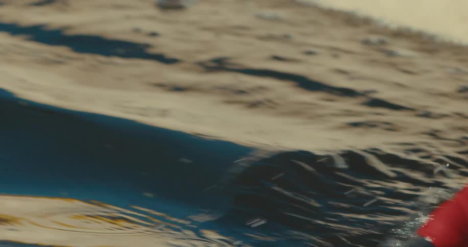 A kayak paddle slices through the water creating a spray of droplets