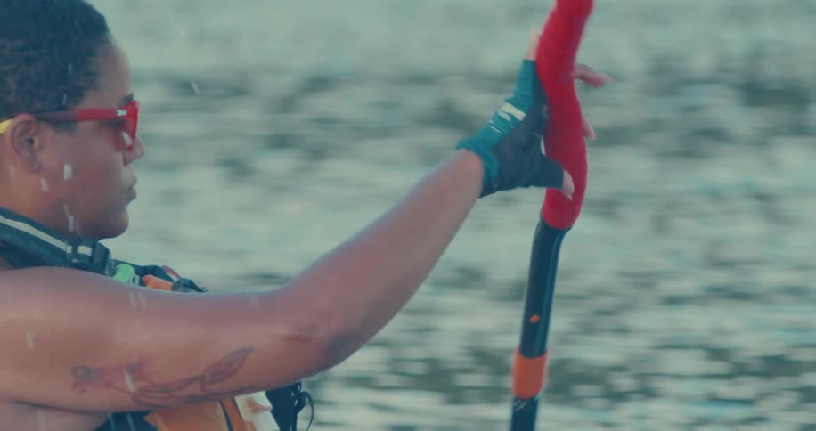 A woman is in the water paddling a kyak