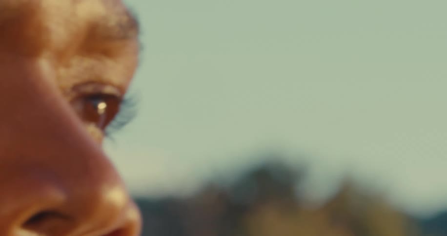 A close up of the eyes of a woman rowing on a canoe on a sunny day