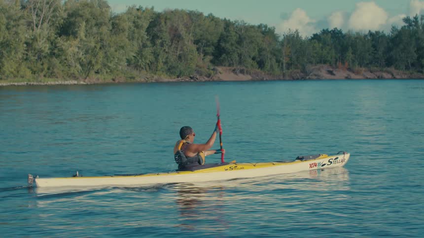 Person canoeing on a river during the day