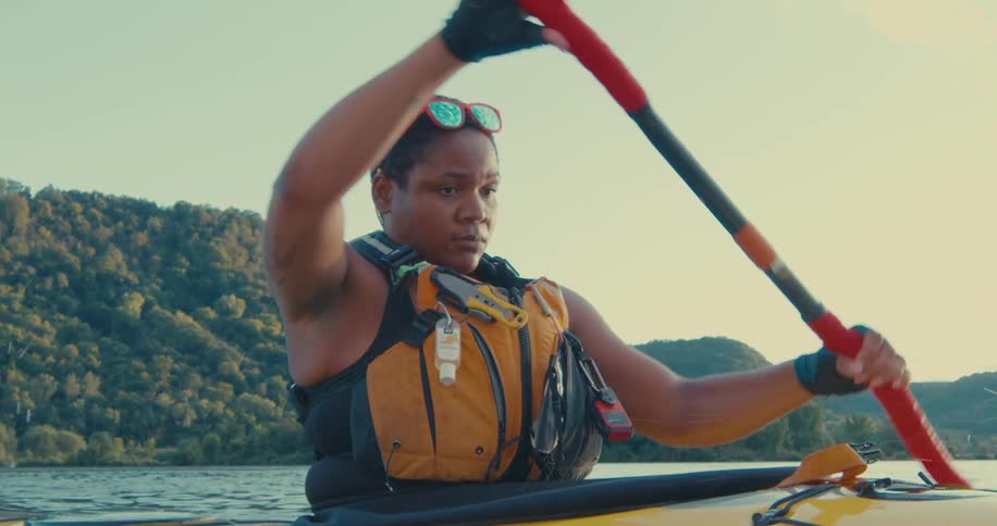 Person paddling a canoe on a river
