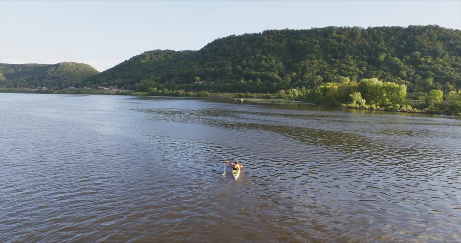 A person is kayaking towards the shore