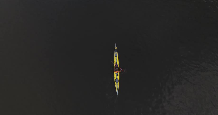 Person paddling on their kayak over the calm lake