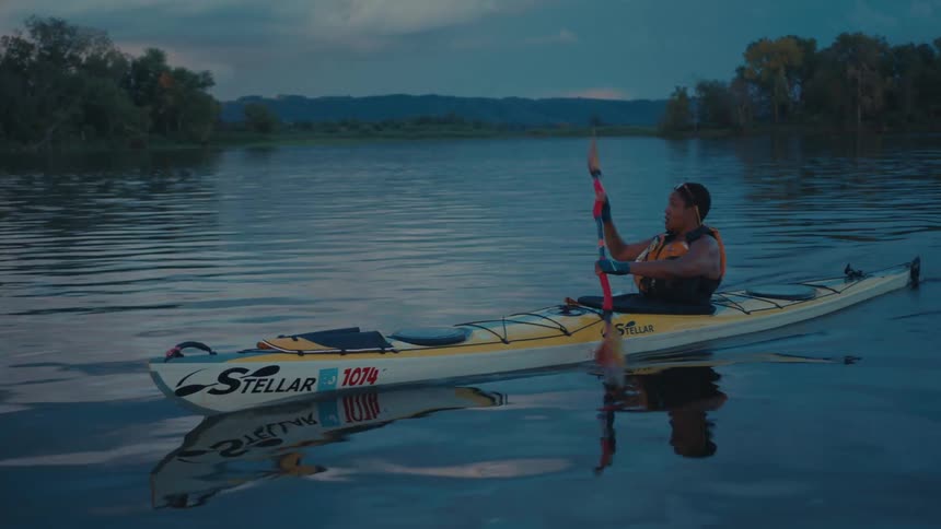 A woman is paddling fast in the kayak