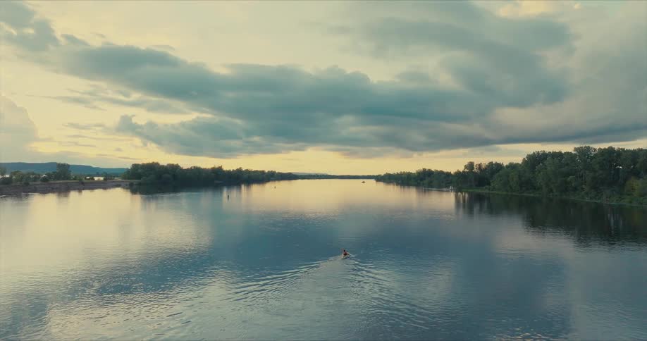 Person isolated on a river canoeing at dawn