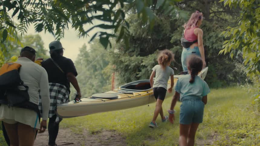 People carrying a canoe boat down a trail