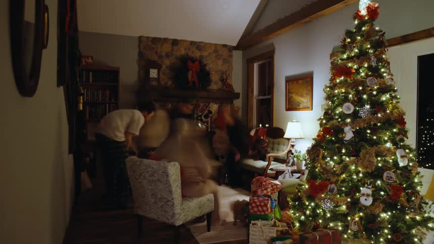 A family moves around in a room with christmas decorations