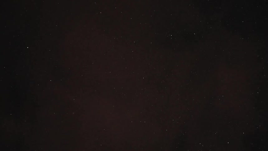 The starry sky on a dark night with some clouds passing in front