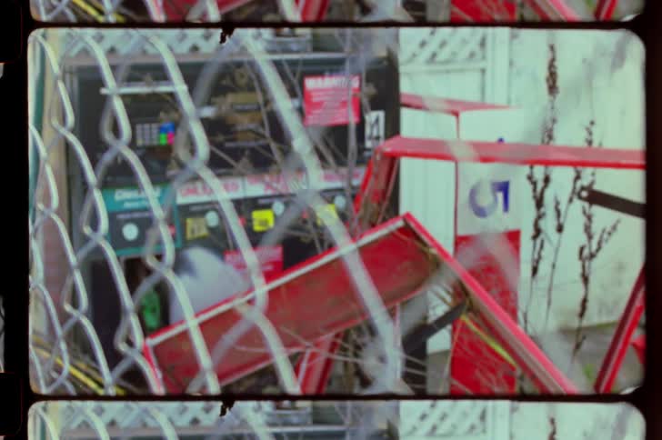 Behind the fence is a gas pump