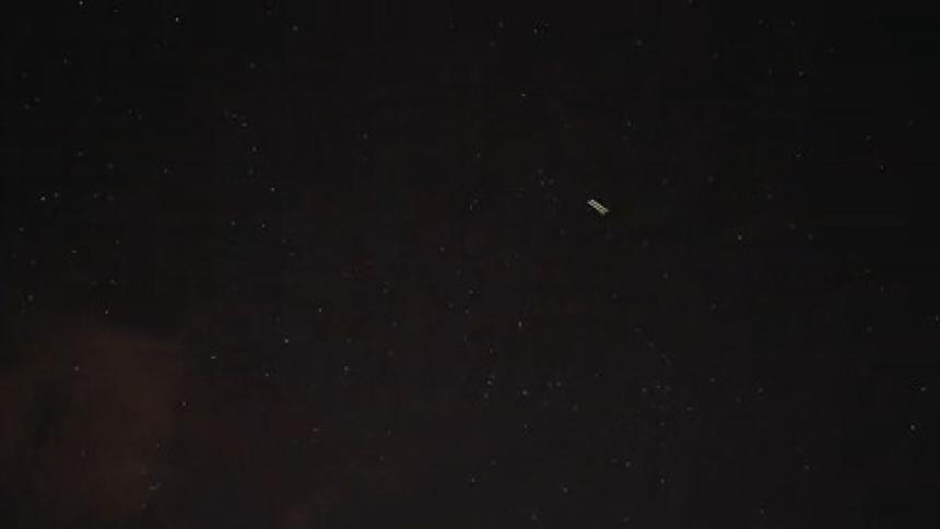 A shooting star goes through the cloudy sky