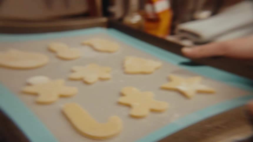 A person puts a pan of cookies in the oven