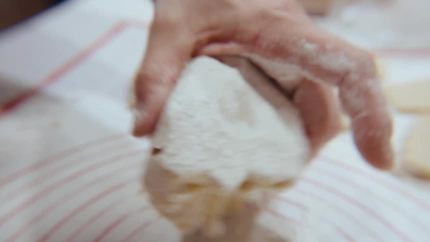 Man cooking and putting wheat into a dough