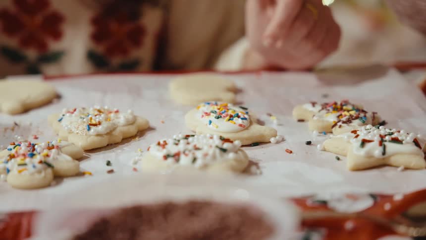 Two women stand behind a sheet of cookies that are homemade