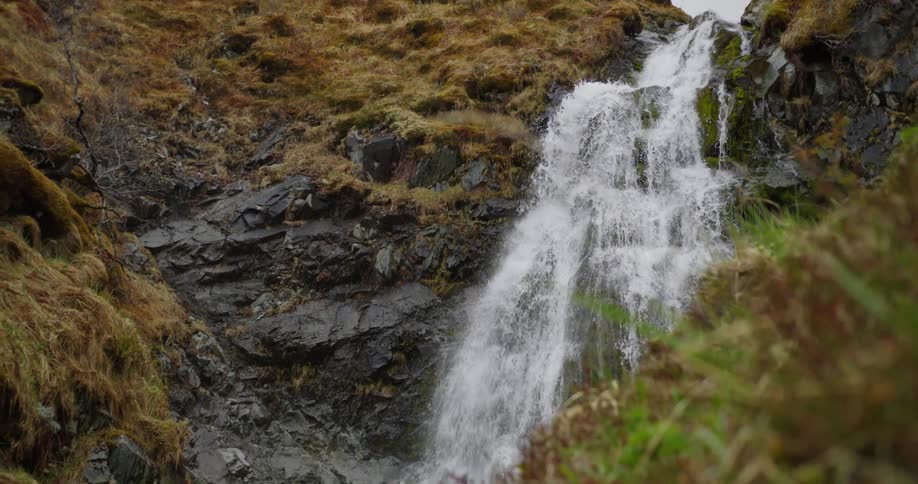A waterfall is flowing down the side of a mountain