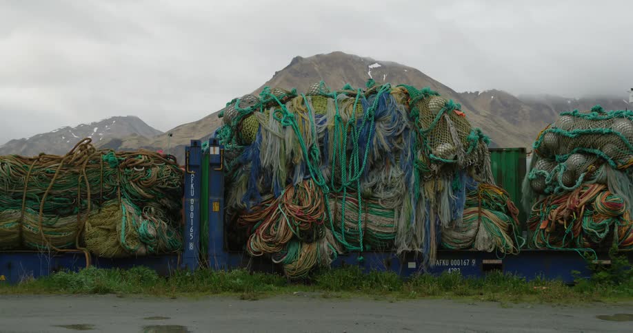 Fishing nets piled up outdoors with a mountain in the background