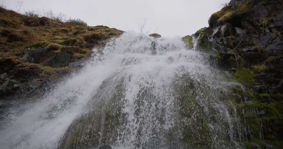 The water cascades down the mosscovered rocks its force creating a thunderous roar and a fine mist that fills the air with a cool spray