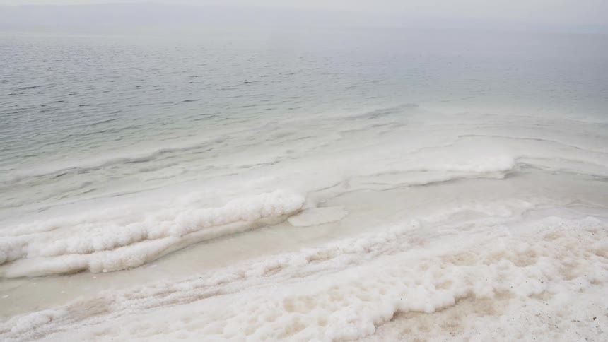 The beach is covered with sea foam