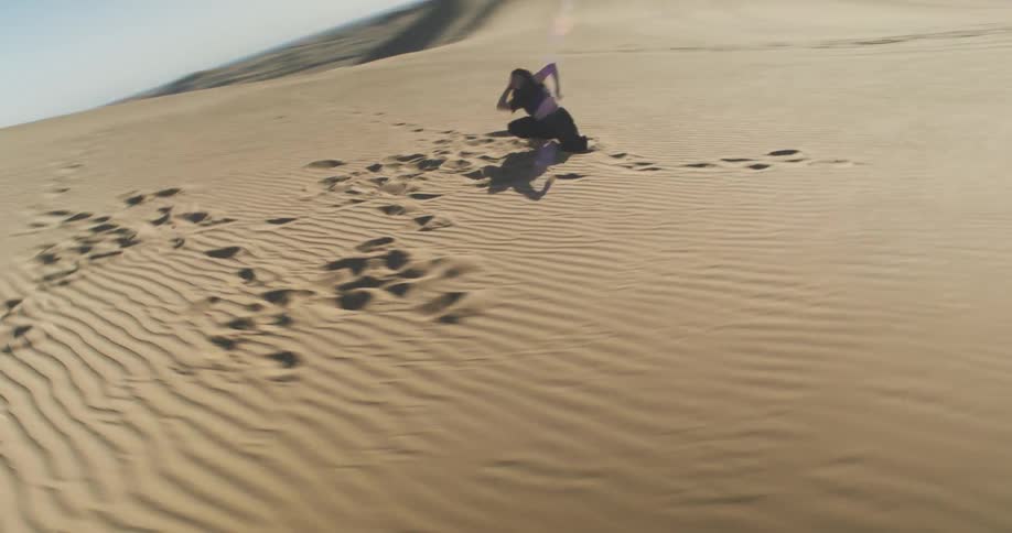 A woman is dancing in the desert