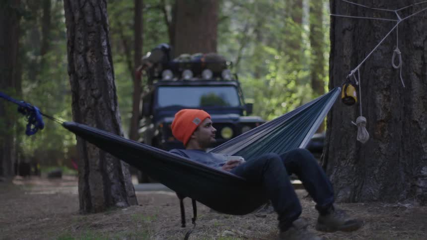 Man swings on a hammock outside