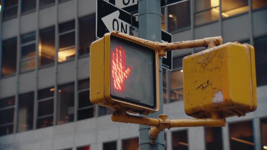 Close up of a traffic light with a stop sign for pedestrians