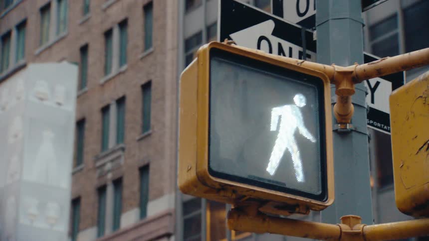A pedestrian crossing signa changing from red to green in the city at daytime