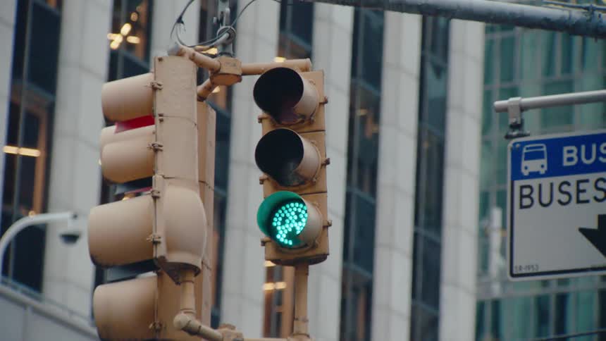 The traffic light previously illuminated with a steady red light now glows green signaling vehicles to proceed through the intersection