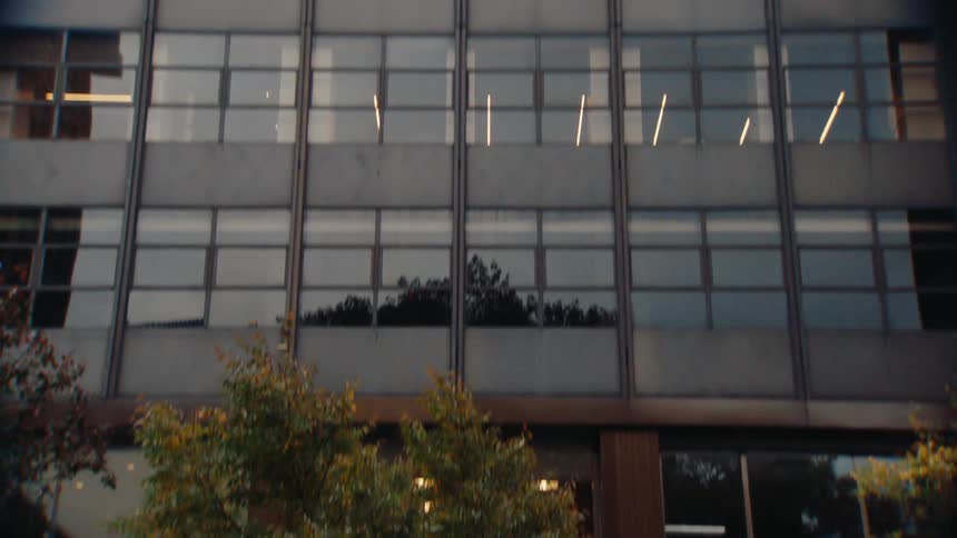 Facade of a modern skyscraper seen during a day on the edge of an urban road