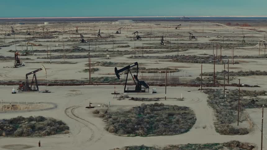 Aerial view of oil machinery in operation through a natural area