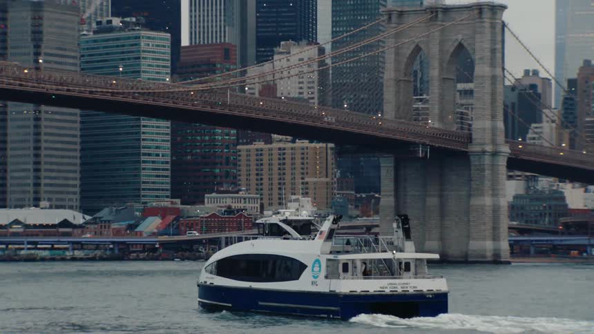 Boat passing through a sea canal and in the background towers and skyscrapers of a metropolis