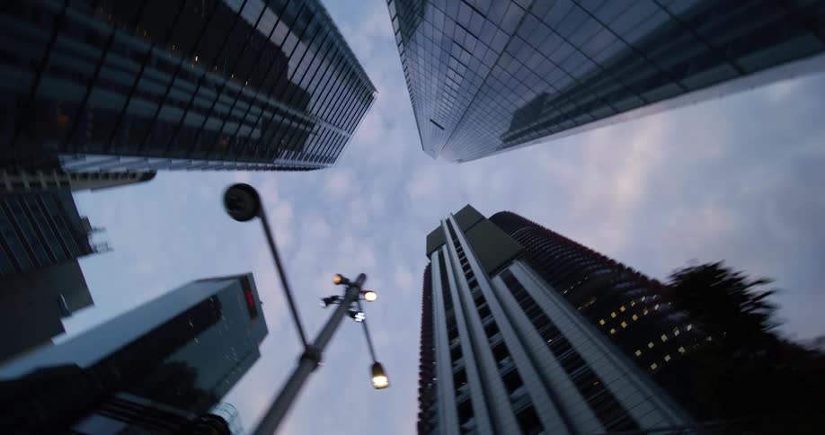 Upward view of modern skyscrapers against a cloudy sky
