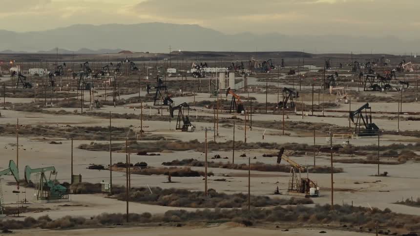 Arid landscape full of oil extraction pumps located in a vast desert expanse
