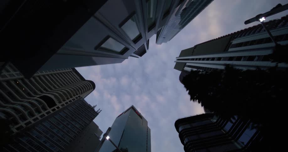 Upward view of modern buildings against a cloudy sky