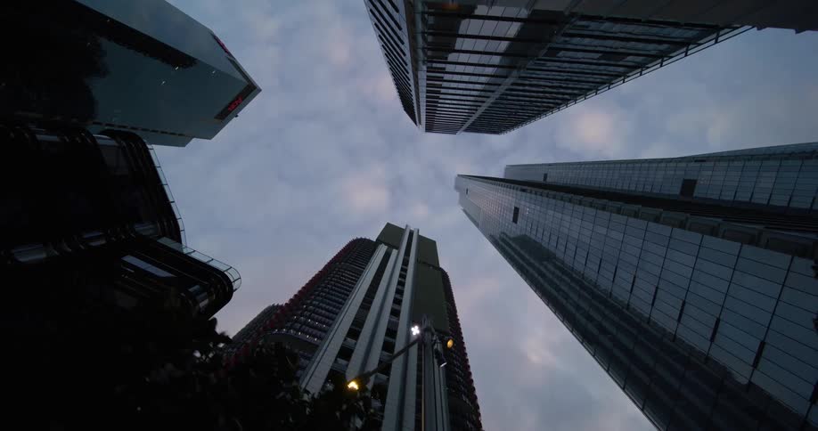 Upward view of modern building towers against a cloudy sky