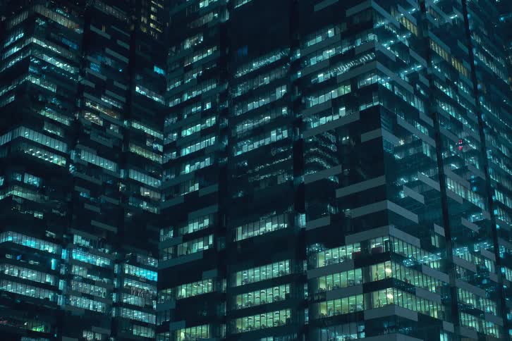 Building lights turn on in office skyscrapers at night
