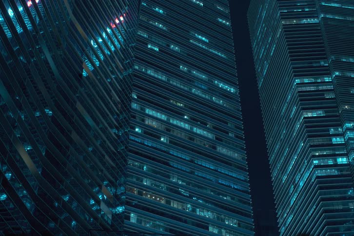 Upward view of modern office buildings with the lights going out at night